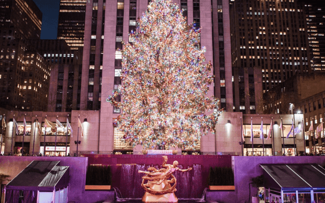 Rockefeller Center Christmas Tree adorned with lights and decorations stands tall above the Rockefeller Center Ice Rink.