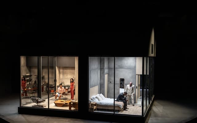 The cast of The Oresteia in the glass-walled set at the Bridge Theatre