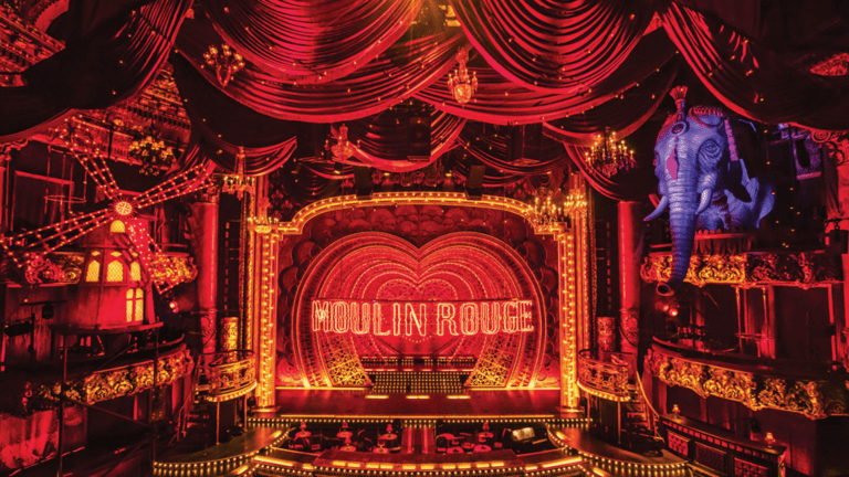 El escenario de Moulin Rouge! en el Al Hirschfeld Theatre con el molino rojo, el elefante azul y el letrero en forma de corazón