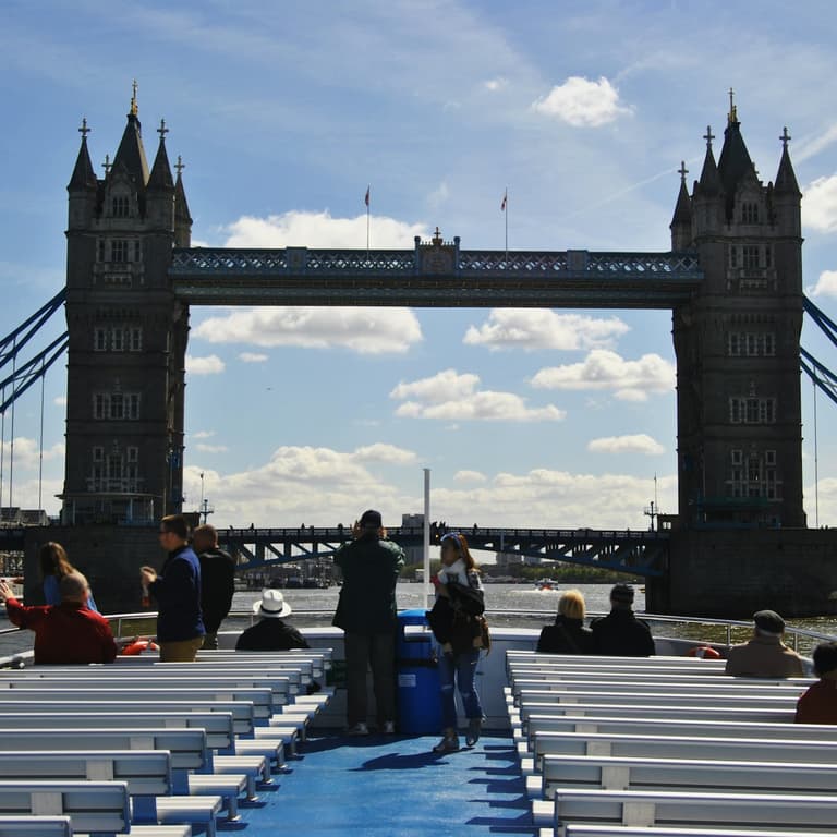 Thames river boat approaching Tower Pier with the Tower of London on the bank