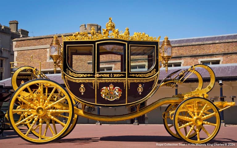Fasaden til Buckingham Palace med porter og gjerder på en sommerdag