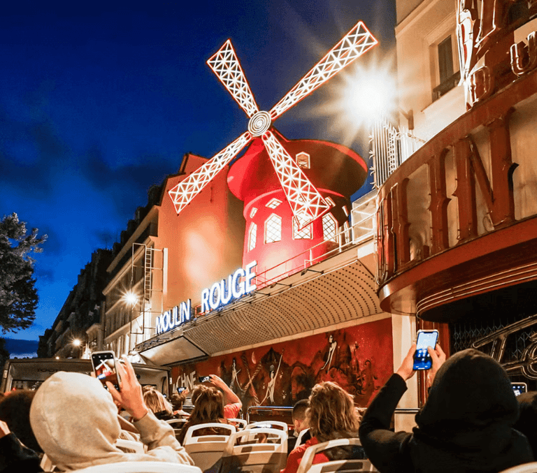 Illuminated red windmill of the Moulin Rouge cabaret at night in Paris