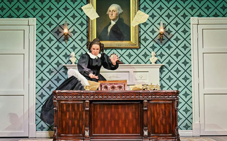 Mary Todd Lincoln ایک سیاہ سوگ کے لباس میں میز پر Oh, Mary! میں Trafalgar Theatre میں