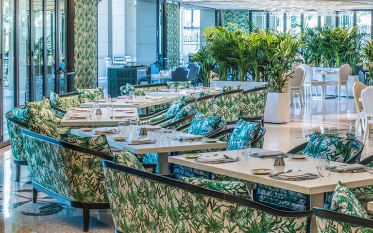The interior of Nikos Taverna at The O2, the Greek-taverna setting for Mamma Mia! The Party, with palm-print banquettes and laid tables