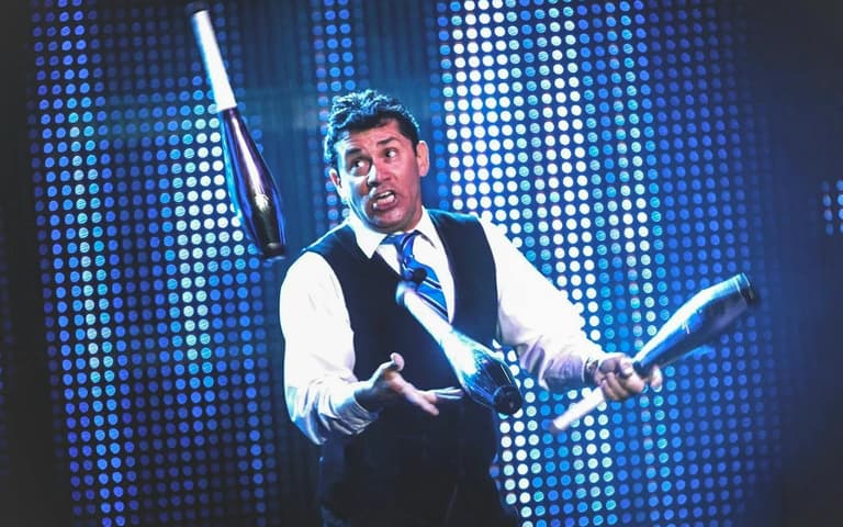A juggler tossing clubs in the air in V The Ultimate Variety Show