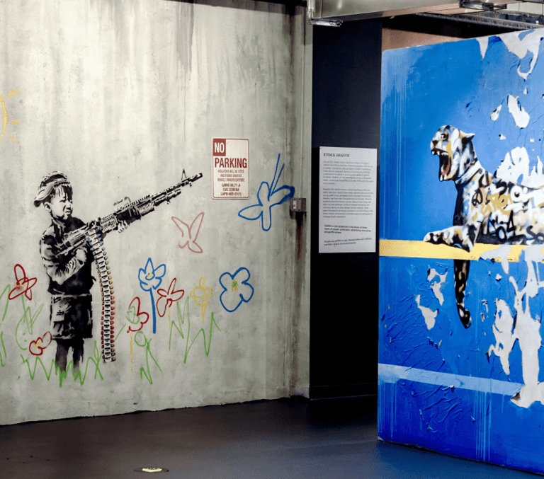 Banksy street art exhibition interior with stencil murals on the walls