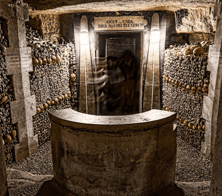 Stacked bones and skulls lining the underground Catacombs of Paris