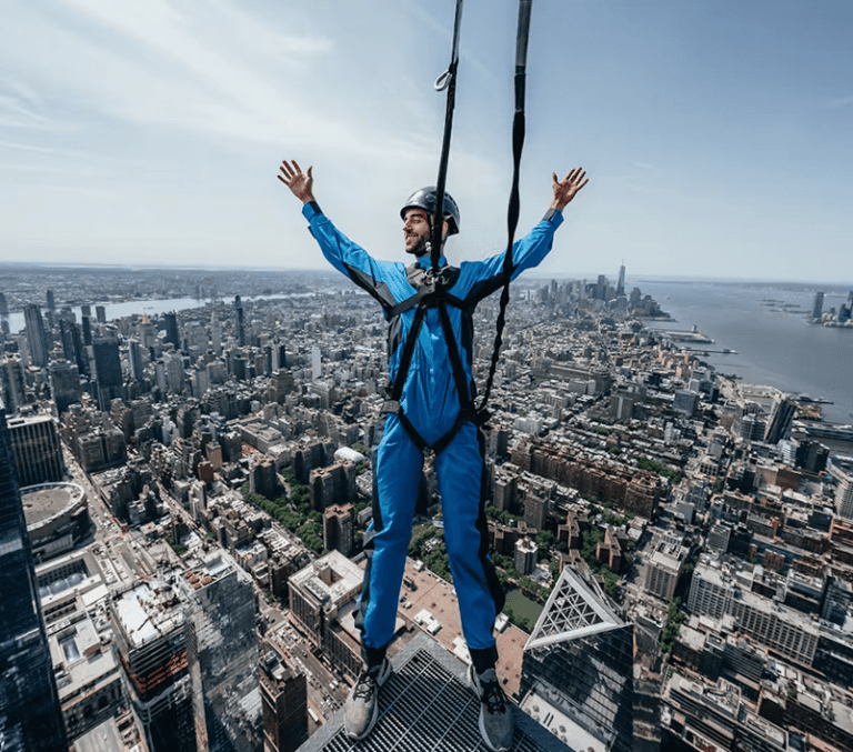 Harnessed City Climb thrill-seeker leaning out over the Manhattan skyline in New York