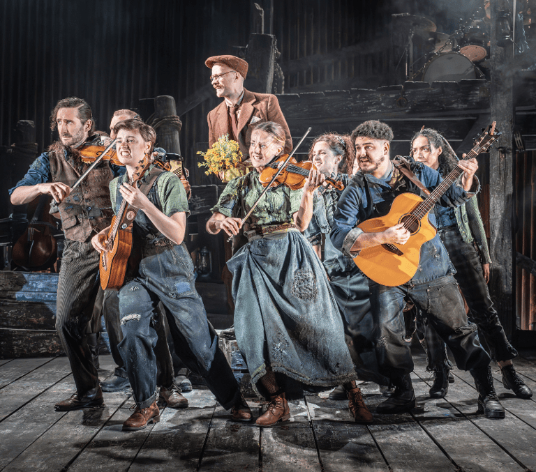 Cast of The Curious Case of Benjamin Button playing folk instruments on stage