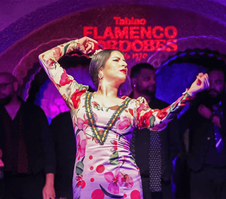 Flamenco dancer in a floral dress performing at a Barcelona tablao show