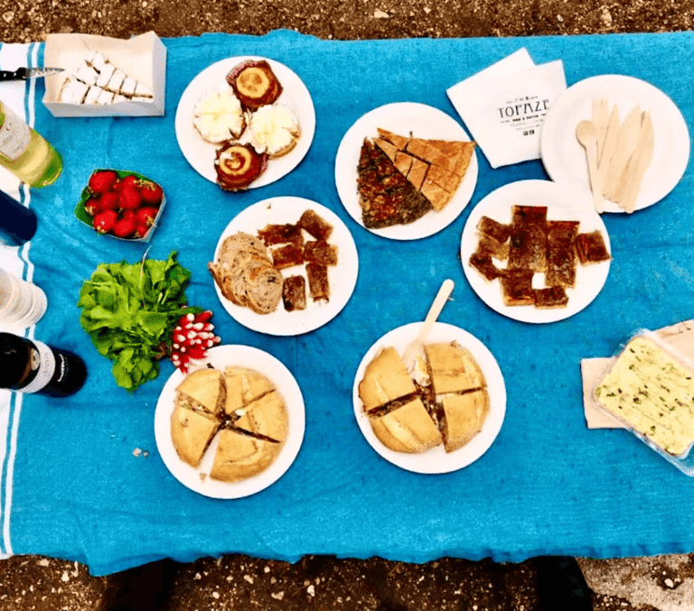 Outdoor spread of French cheeses, bread and charcuterie on a blue table on the French Riviera