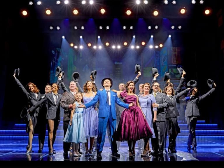La compañía completa de Sinatra: The Musical en un número final, sombreros en alto, con Frank en el centro vestido de traje azul