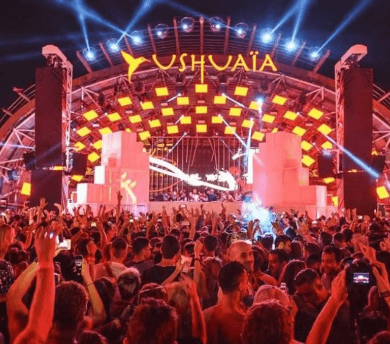 Pyrotechnic fire jets and the lit Ushuaia sign above the night crowd in Ibiza