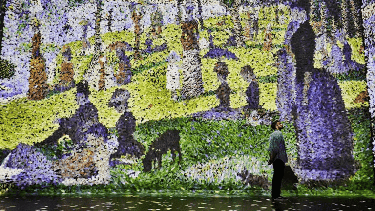 Visitors surrounded by projected artworks at Frameless immersive art experience in London