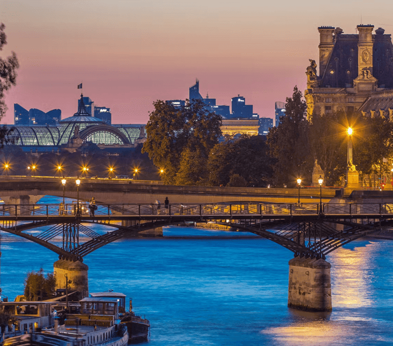 Pont des Arts bridge over the Seine at dusk with the Louvre in Paris