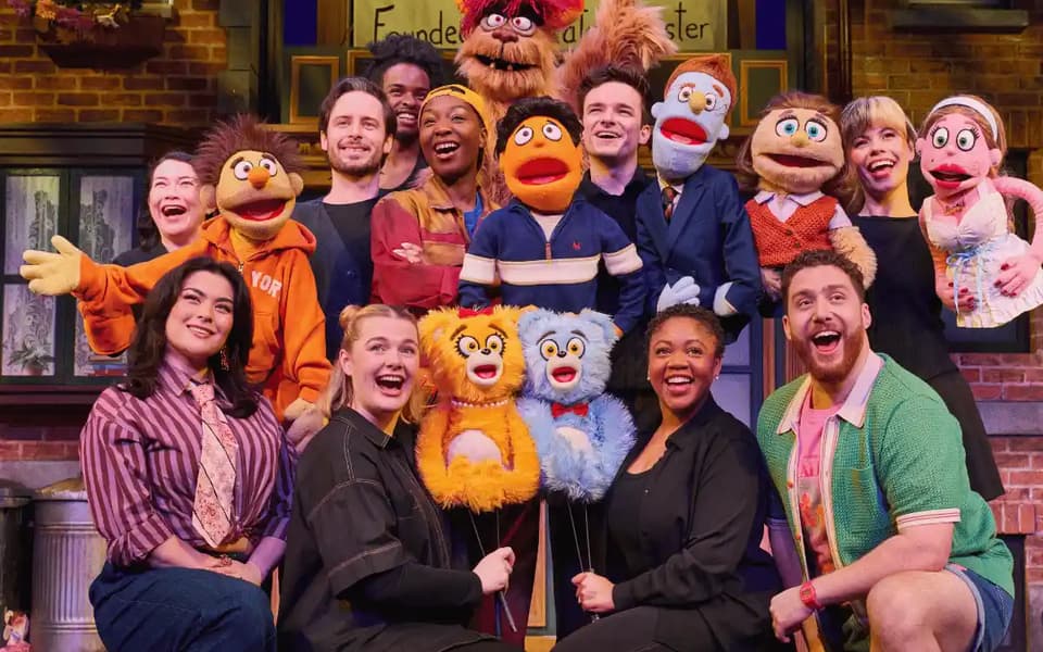 The 2026 London company of Avenue Q with their puppets at the Shaftesbury Theatre