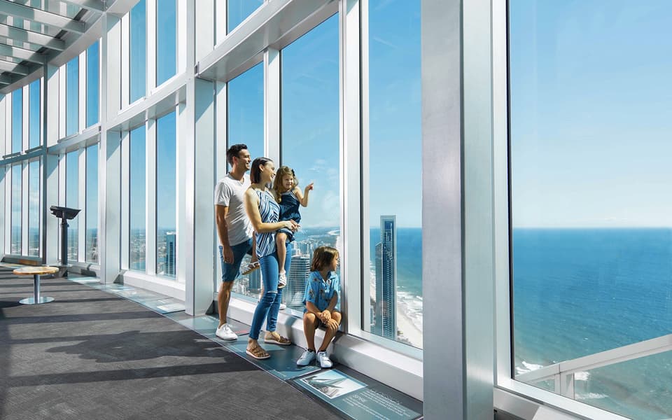 Family at the SkyPoint observation deck looking out over the Gold Coast coastline and ocean
