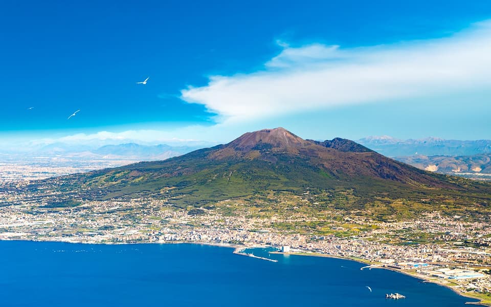 Mount Vesuvius rising over the Bay of Naples and coastal town near Herculaneum and Pompeii