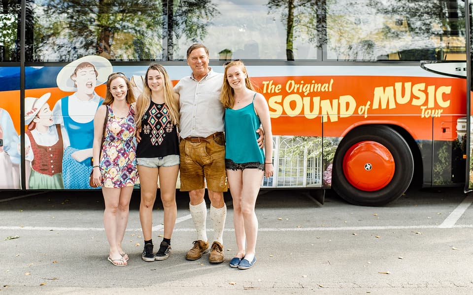 Family posing by the Original Sound of Music tour bus in Salzburg, Austria
