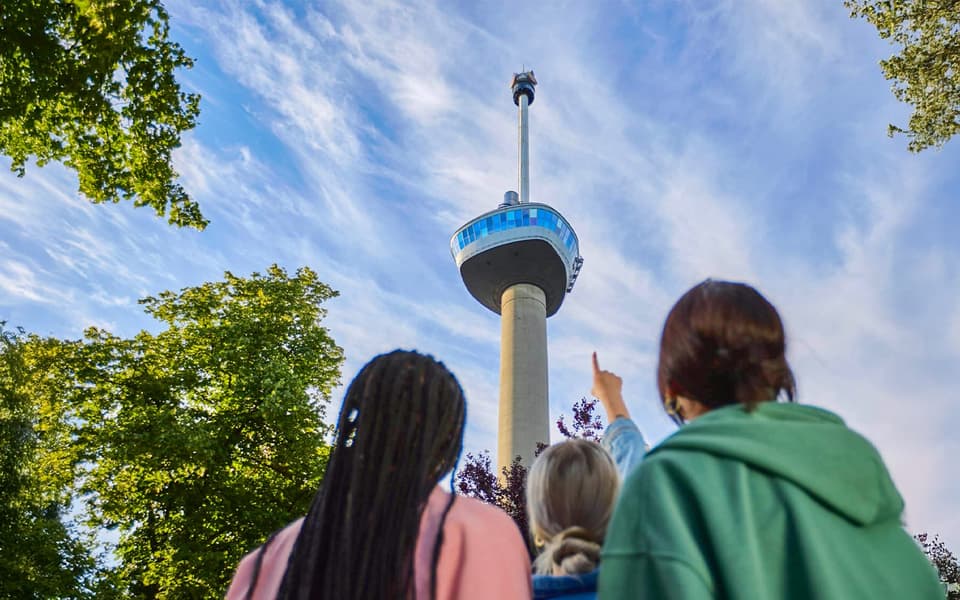 Visitors gazing up at the Euromast observation tower in Rotterdam on a sunny day