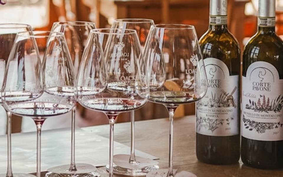 Row of wine glasses and two Brunello di Montalcino bottles set for a tasting in Tuscany