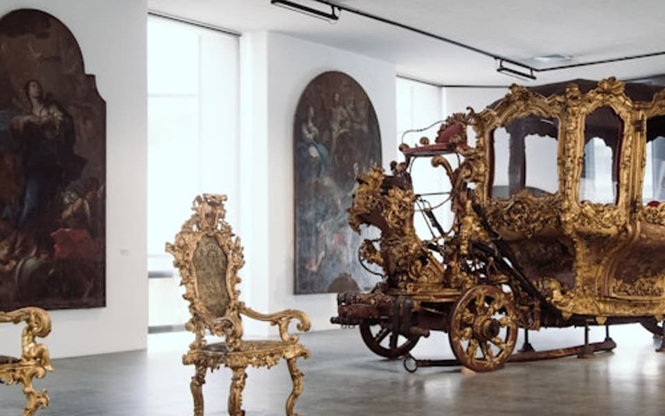 Sicilian museum gallery in Messina with a gilded baroque carriage and ornate golden chairs