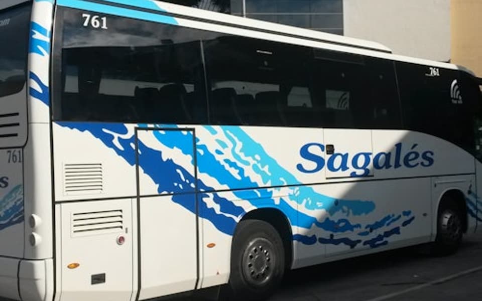 White and blue Sagalés coach bus parked outside Girona ready for a Christmas transfer