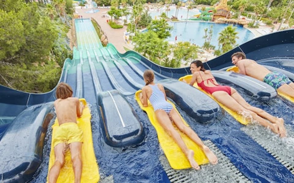 Racers sliding down a multi-lane mat water slide at a Vila-seca water park