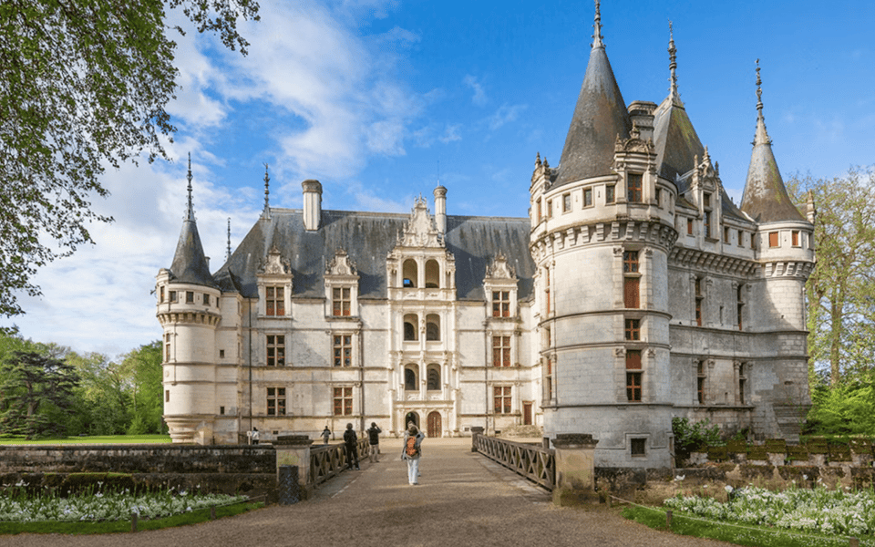 Loire Valley chateau with conical turrets and a visitor crossing the bridge through formal gardens