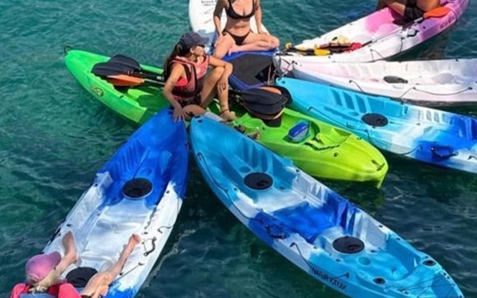 A group of people with their kayaks nose to nose in the Bay of Palma