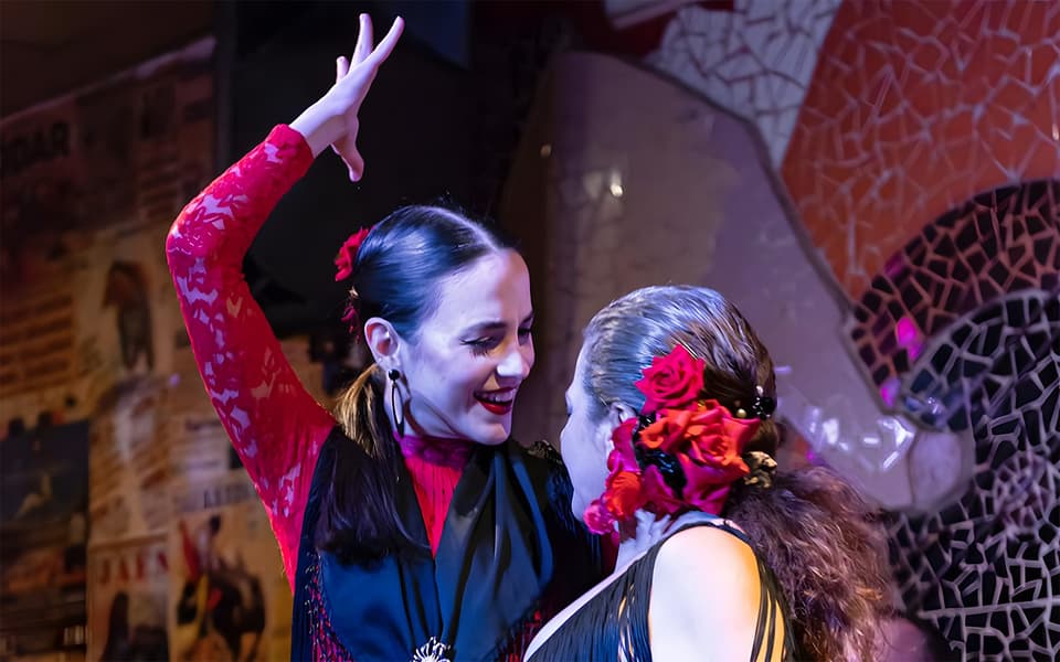 Two flamenco dancers in red and black performing at night in Valencia