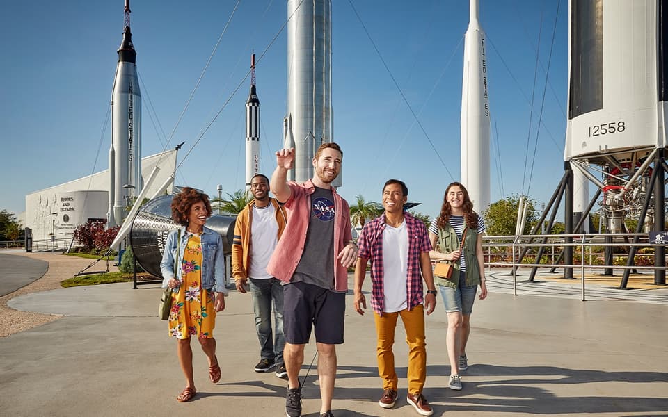 Friends walking through the Rocket Garden of NASA rockets near Orlando, Florida
