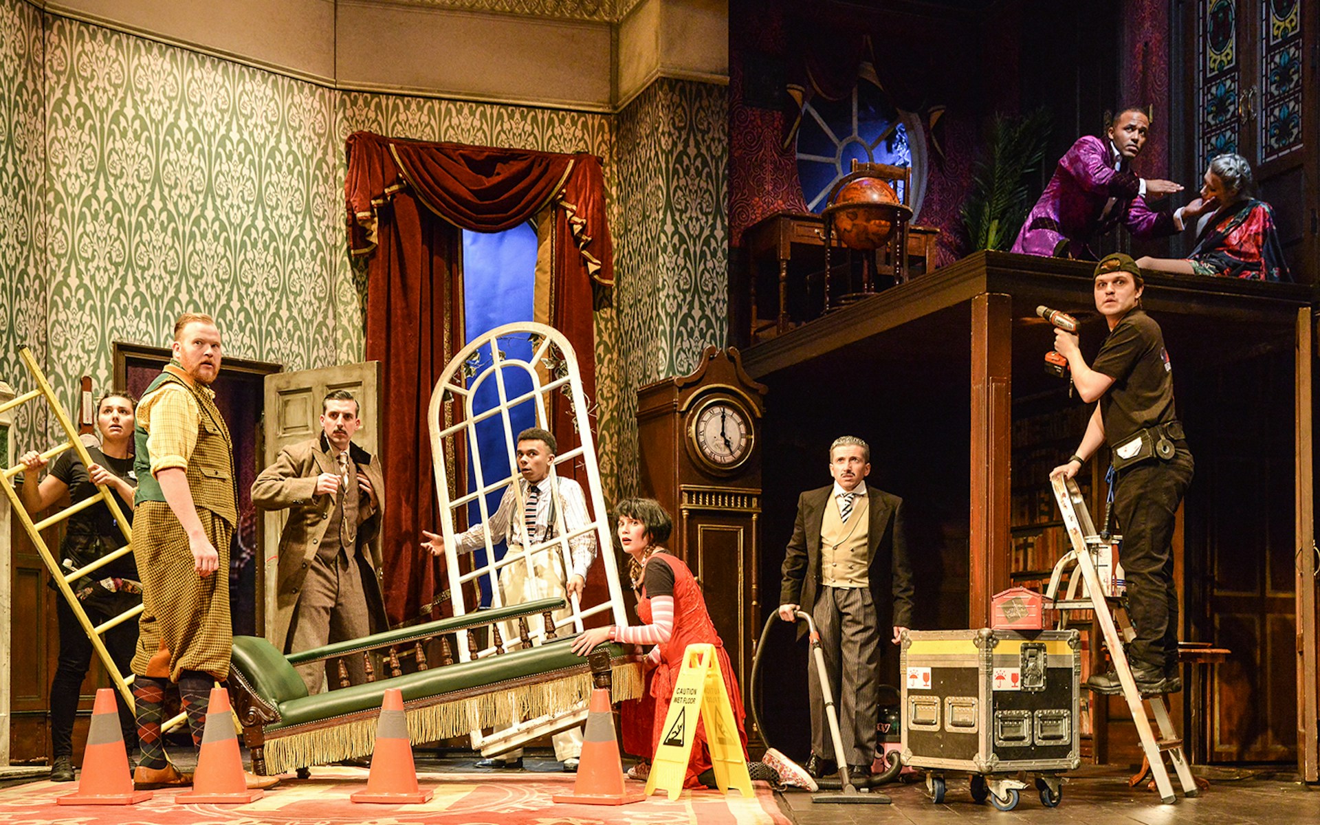 Cast members on stage during a chaotic scene from "The Play That Goes Wrong