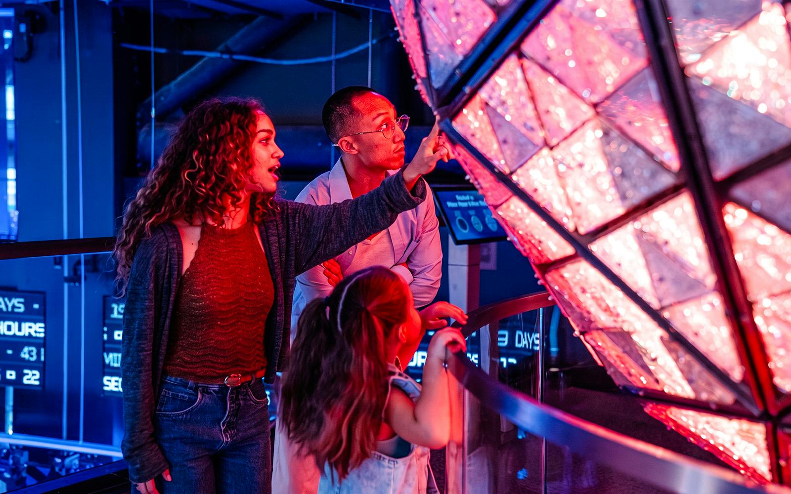 Visitors viewing an illuminated New Year’s Eve Ball exhibit