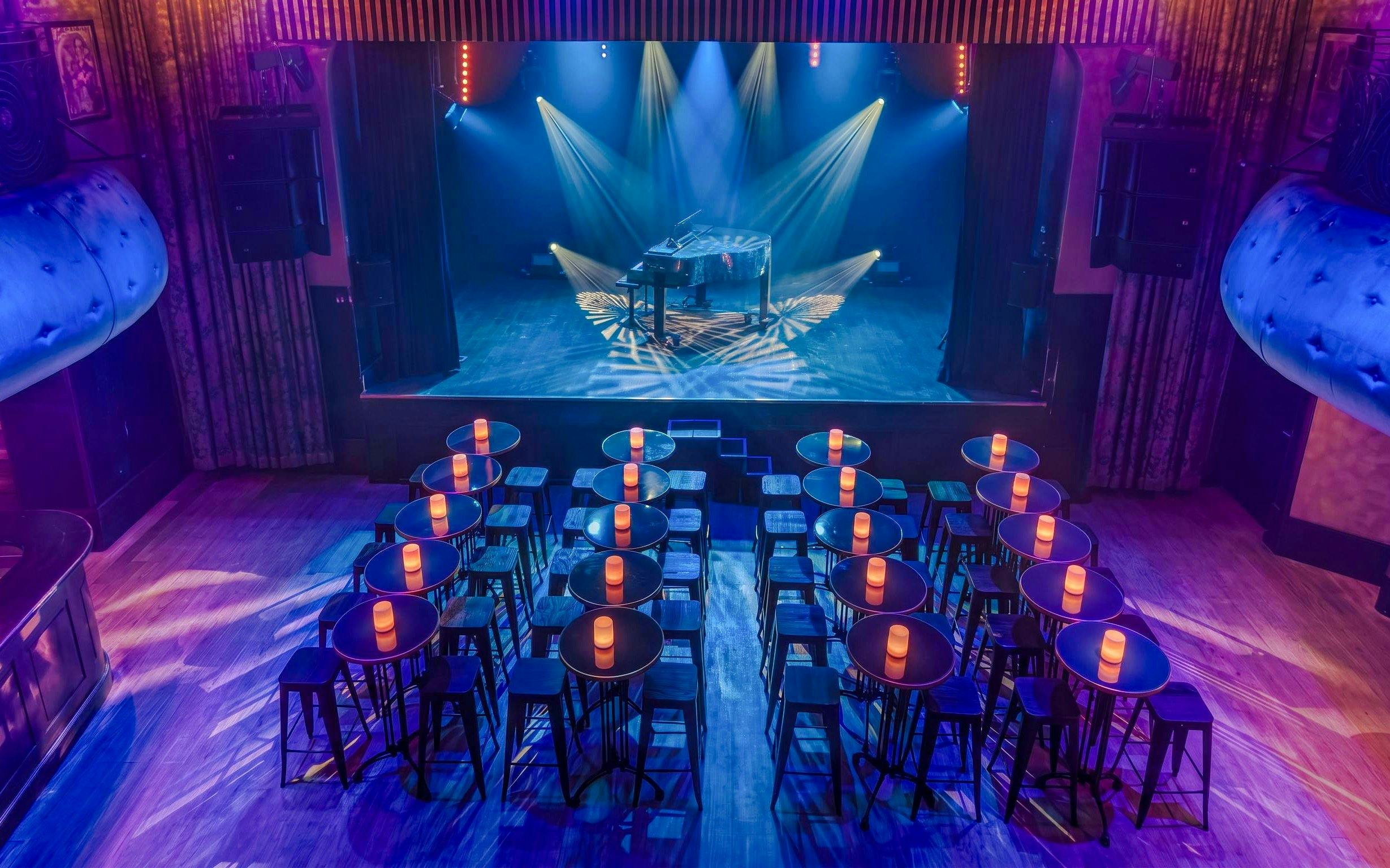 Cabaret stage with piano and seating at Madame Arthur show, Paris.