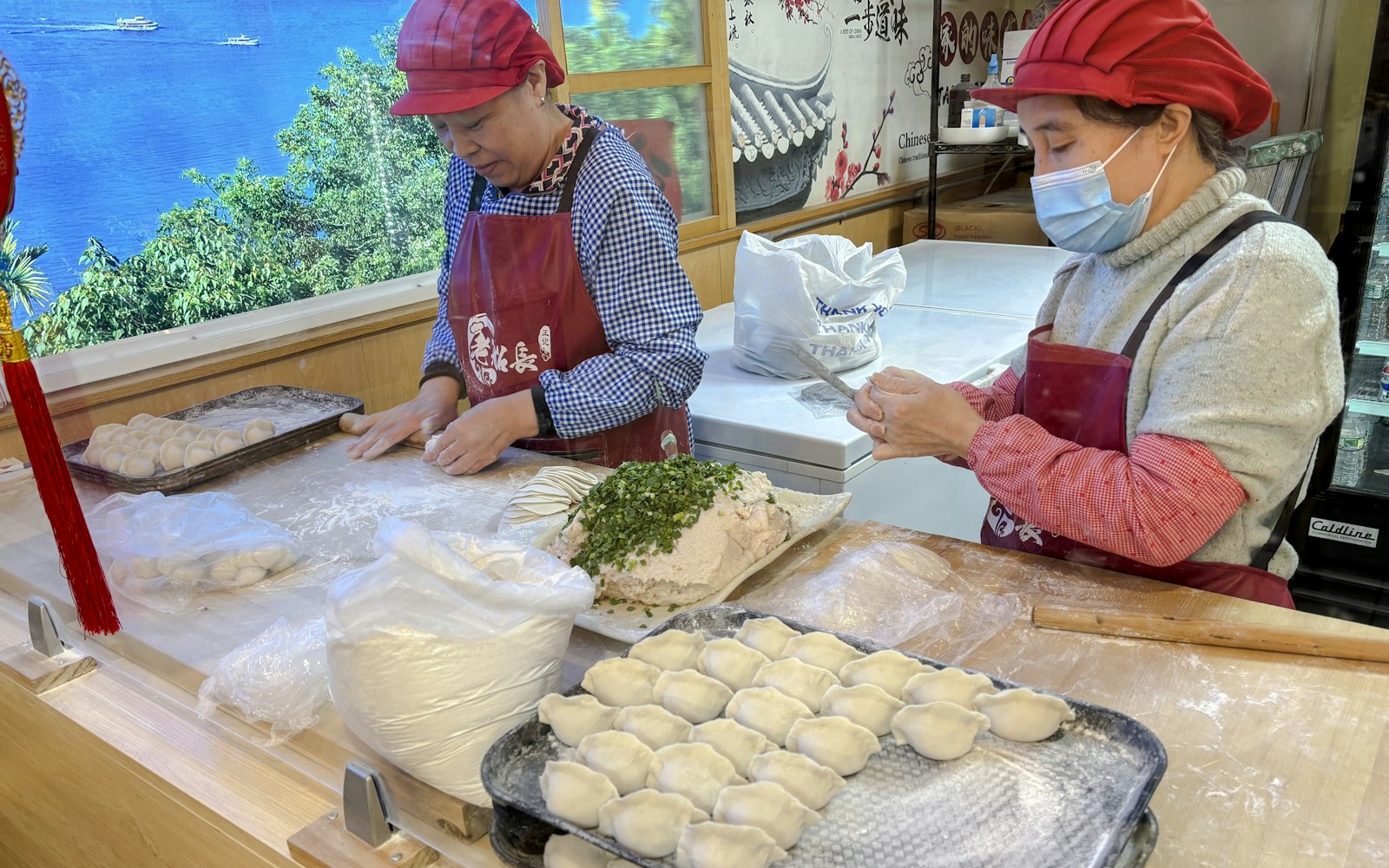 Dumplings being prepared by hand in a Flushing food shop