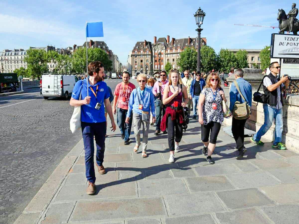 Guide leading group through Paris streets on Notre Dame tour.