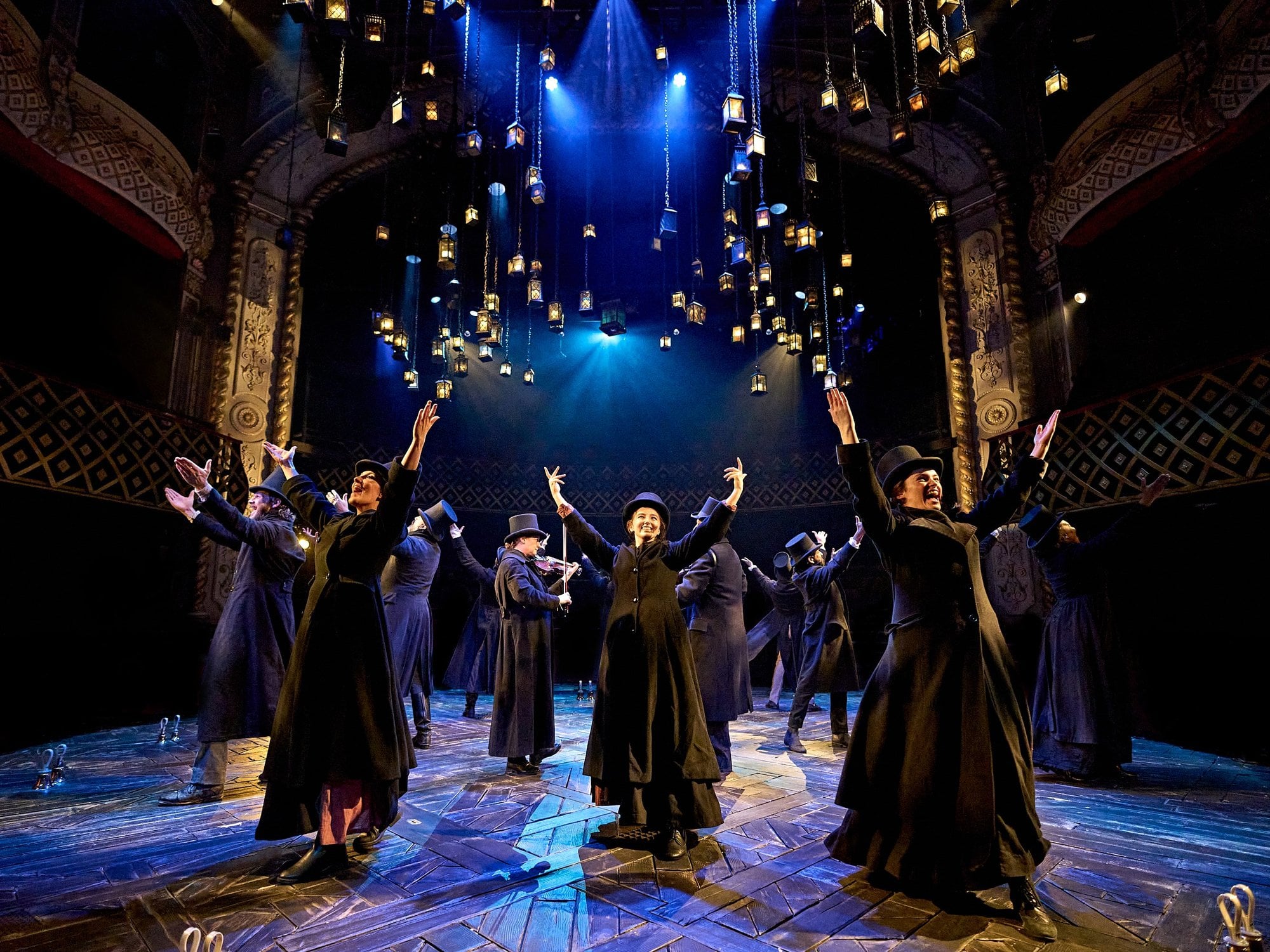 A Christmas Carol at The Old Vic (previous year's production): The company in black coats and top hats beneath the lanterns. Photo: Manuel Harlan